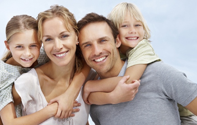 Portrait of a happy mature man and woman carrying kids on back